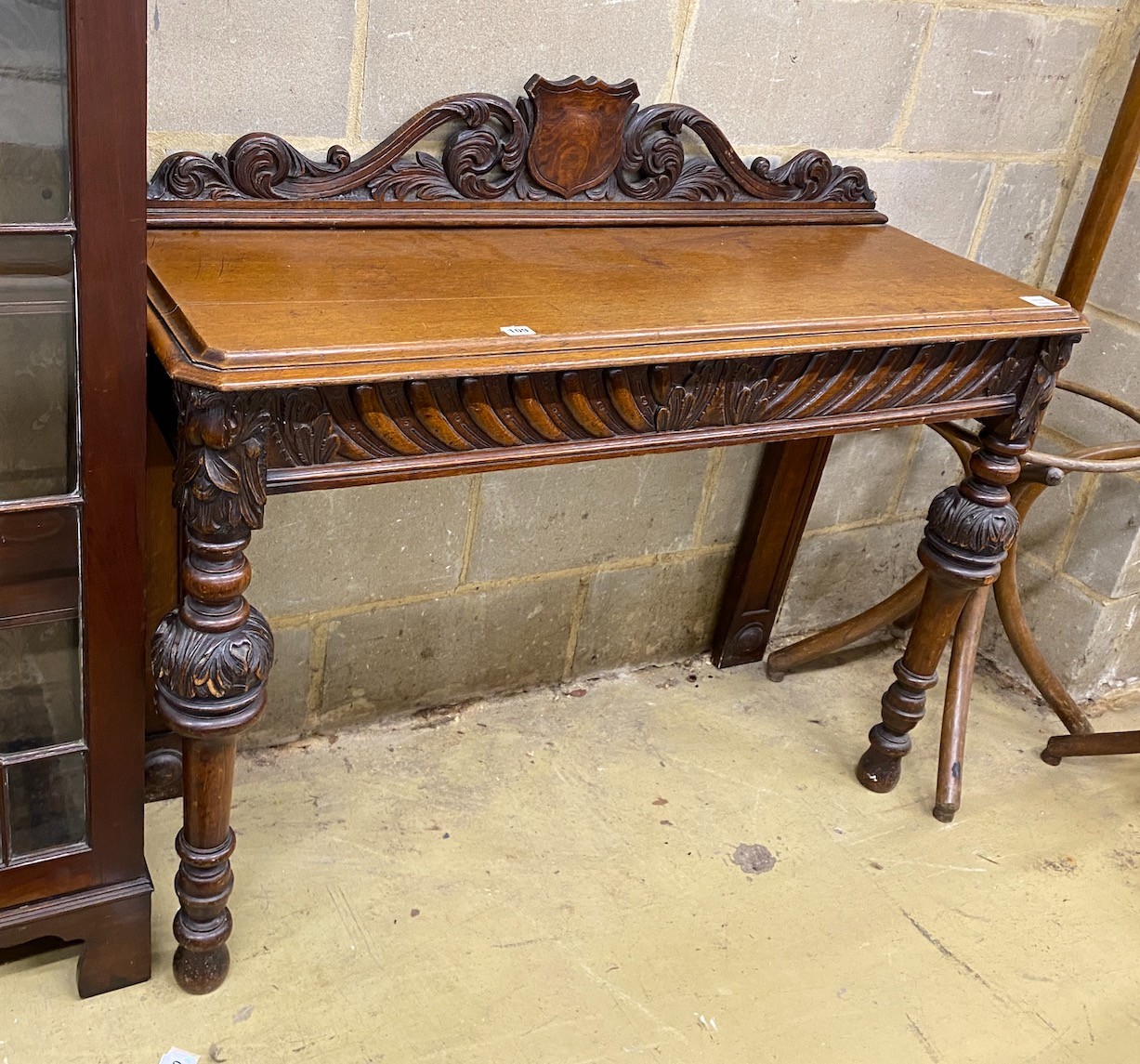 A Victorian oak console table, vacant shield cartouche and scrolling acanthus surmount to back, width 120cm, depth 42cm, height 102cm